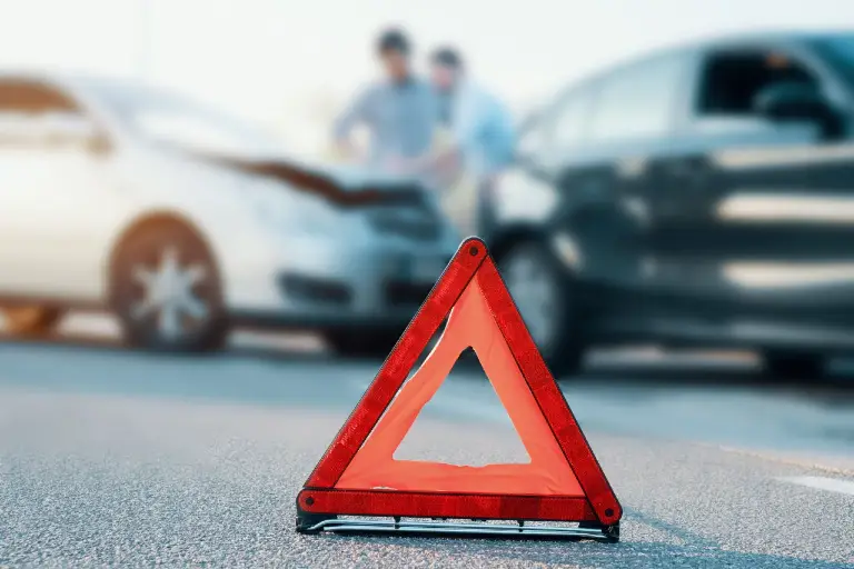 Car-Accidents-in-Orland-Park-scaled-1 warning road sign on a road with two clashed cars behind