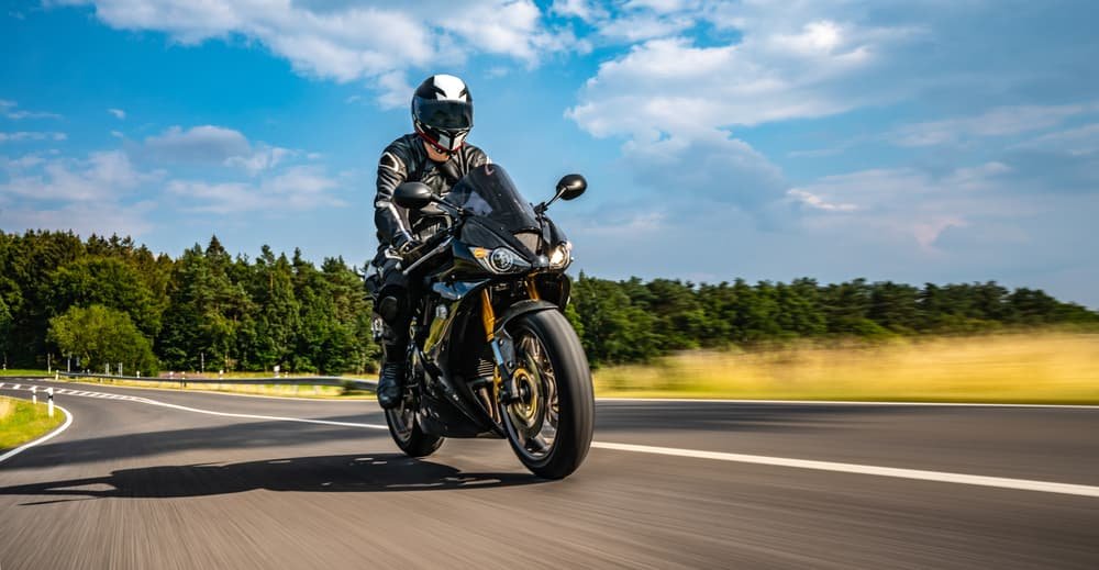 Motorcyclist riding on an Illinois highway while following traffic laws.