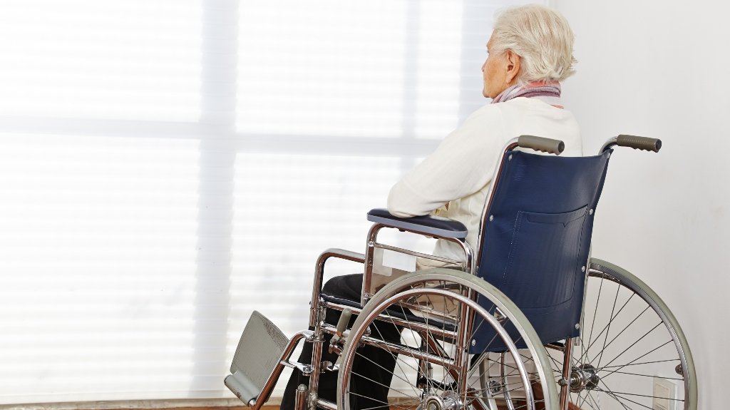 Elderly Nursing Home Resident Sitting Alone In Wheelchair