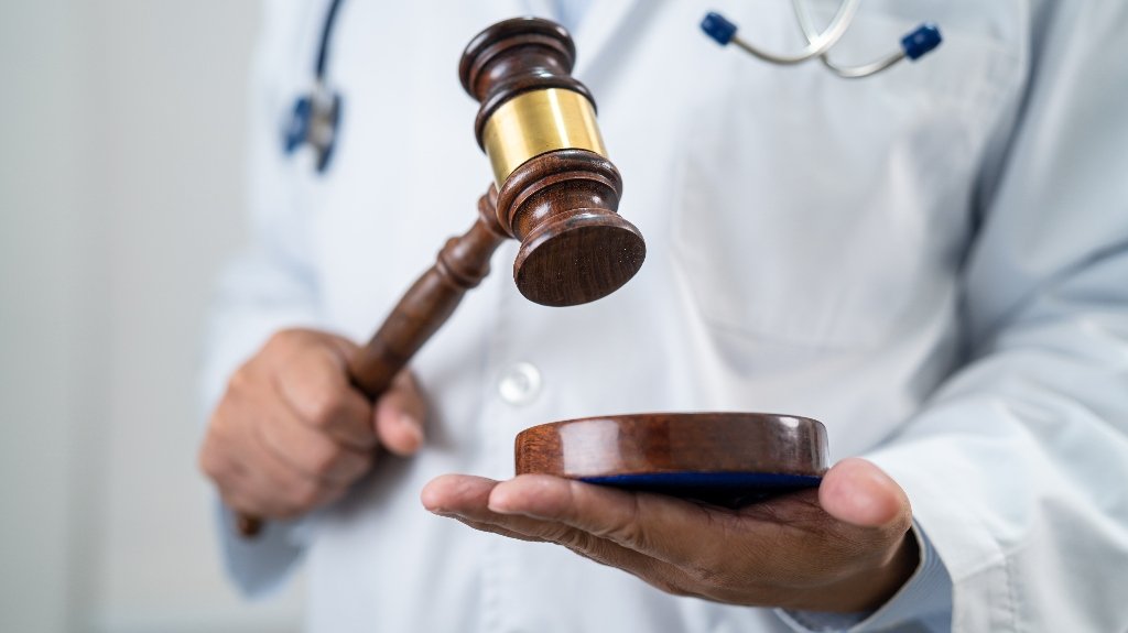 Doctor Holding Judge Gavel Representing Expert Medical Testimony