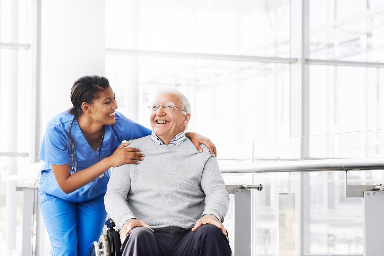 Nurse assisting an elderly nursing home resident in a wheelchair
